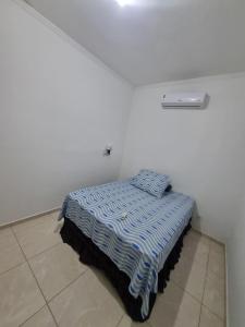 a small bed in a white room with a bed sqor at Casa Atenas 2 in Três Lagoas