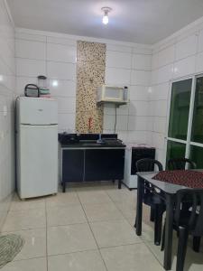 a kitchen with a refrigerator and a table with chairs at Casa Atenas 2 in Três Lagoas +8 photos