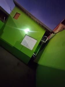 a green house with a window in the middle at Casa Atenas 2 in Três Lagoas