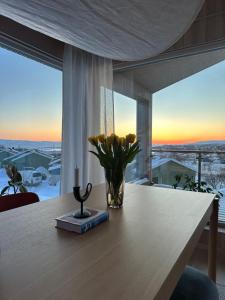 瓦德瑟Villa Vadsø的一张带蜡烛的桌子上的花瓶