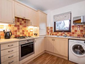 a kitchen with a washer and dryer in it at Holm Dell Apartment in Inshes