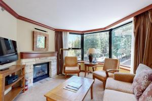 un salon avec une cheminée et une télévision dans l'établissement Everline Resort & Spa 607B, à Olympic Valley