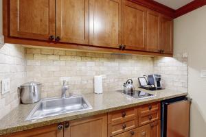 une cuisine avec des armoires en bois et un évier dans l'établissement Everline Resort & Spa 607B, à Olympic Valley