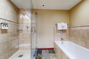 une salle de bain avec baignoire et douche dans l'établissement Everline Resort & Spa 607B, à Olympic Valley