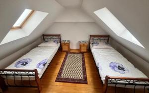 two beds in a attic room with two windows at Privat vila 303 in Martin