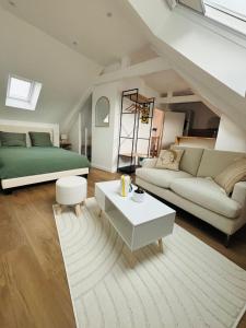 a living room with a bed and a couch at Sous les étoiles de Brocéliande in Campénéac