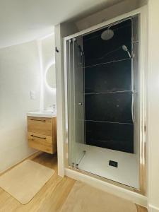 a bathroom with a glass shower with a sink at Sous les étoiles de Brocéliande in Campénéac