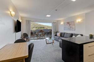 ein Wohnzimmer mit Sofa und Tisch in der Unterkunft Stunning Lakefront 2-bed 2-bath with lake views in Queenstown