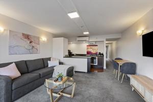 ein Wohnzimmer mit Sofa und Tisch in der Unterkunft Stunning Lakefront 2-bed 2-bath with lake views in Queenstown