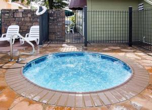 a pool in a yard with chairs and a fence at Extended Studio Suites Hotel- Bossier City in Bossier City +16 photos