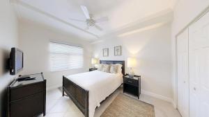 ein Schlafzimmer mit einem Bett und einem Deckenventilator in der Unterkunft South Bay Beach Club #33 - 3 Bedroom 2 Bathroom Unit in George Town