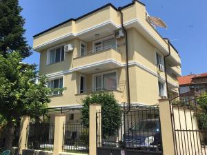 a yellow house with a black fence at Villa Diana in Sozopol