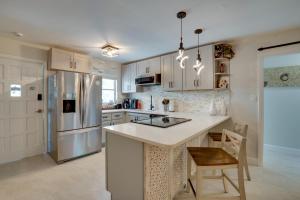 a kitchen with white cabinets and a kitchen island at Walk to Redington Beach Renovated Duplex with Patio in St Pete Beach