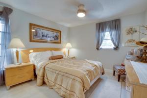 a bedroom with a bed and a dresser and a table at Walk to Redington Beach Renovated Duplex with Patio in St Pete Beach