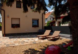 two chairs and a bench in front of a house at Holiday Homes in Mezokövesd - Nordungarn 44895 in Herketytanya