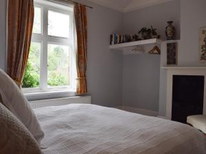 un dormitorio con una cama y una ventana en Wisteria Loft-24773, en Tenbury