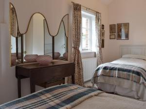 1 dormitorio con espejo en un tocador junto a la cama en Wisteria Loft-24773, en Tenbury
