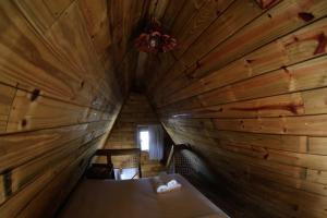 an attic room with a bed in a wooden cabin at Pousada Bellissima Italia in Luis Correia