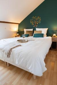a large white bed in a room with a green wall at La maison du jeu cnpe hypercentre plage 8pers jeux video et de société in Gravelines