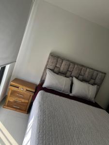 a bedroom with a bed with a wooden night stand at Encanto Del Parque in Moniquirá