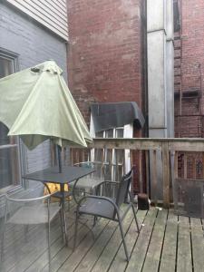 a table and chairs with an umbrella on a deck at Spacious apartment in dowtown Montreal in Montréal