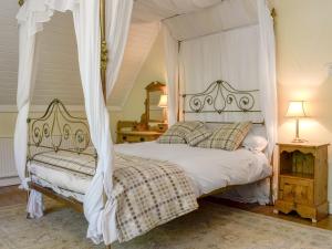 Un dormitorio con una cama blanca con dosel. en Trem Yr Ynys, en Betws-y-coed 10 fotos más