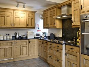cocina grande con armarios y electrodomésticos de madera en Trem Yr Ynys, en Betws-y-coed
