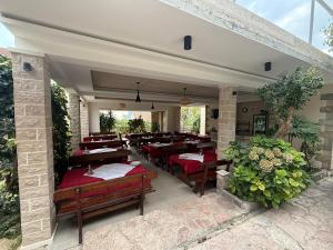 a restaurant with wooden tables and chairs on a patio at B&B Guest House Vasiljevic in Herceg-Novi