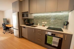 une cuisine avec un évier et un réfrigérateur dans l'établissement New 2 bedroom Holiday home with over 50 amenities in Queenstown, NZ, à Queenstown 19 autres photos