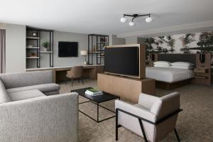 a living room with a bed and a television at Denver Marriott South at Park Meadows in Lone Tree