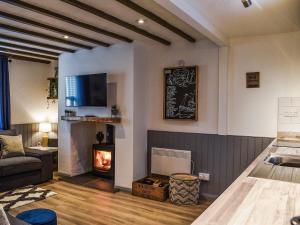 ein Wohnzimmer mit Kamin und Couch in der Unterkunft Low Quay Cottage in Conwy