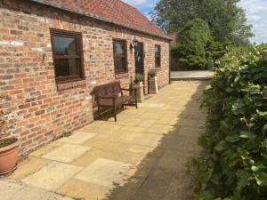 a bench sitting outside of a brick building at Lodge Cottage in York