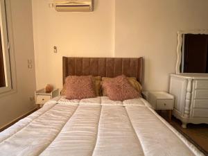 - un lit avec des oreillers roses dans une chambre dans l'établissement Mini-villa Imiouadar vue mer , grand confort, à Agadir