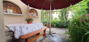 a table with an umbrella and a wooden bench and a table with a tableablish at Apartment in Balatonföldvár 18542 in Balatonföldvár