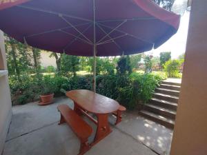 a table with a purple umbrella and a bench with a chair at Apartment in Balatonföldvár 18542 in Balatonföldvár