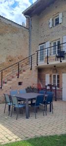a patio with a table and chairs in front of a building at La Belle Bourguignonne in Crêches-sur-Saône