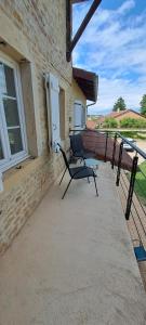 a chair sitting on the porch of a building at La Belle Bourguignonne in Crêches-sur-Saône +11 photos