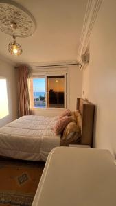 une chambre avec un lit, un canapé et une fenêtre dans l'établissement Mini-villa Imiouadar vue mer , grand confort, à Agadir