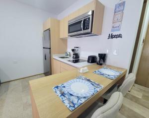 a kitchen with a table with a microwave and a stove at Live Playa Beach, Luxury & 5th Av at your doorstep in Playa del Carmen