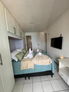 a bedroom with two beds and a flat screen tv at Apartamento vista mar no mucuripe in Fortaleza