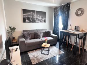 a living room with a couch and a piano at Appartement 2 pièces à Rosny-sous-Bois à quelques pas du Métro in Rosny-sous-Bois