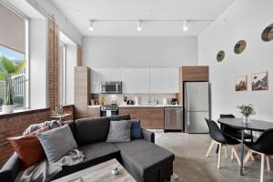 Una sala de estar con un sofá y una cocina. en Stunning Downtown Apartment with Pool, Laundry, Parking, en Dallas