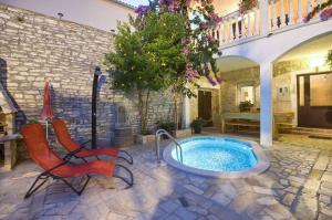 a patio with a hot tub and two chairs at Apartments in Medulin - Istrien 9360 in Medulin