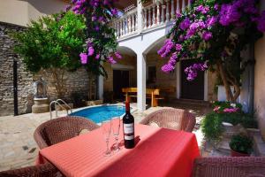 a red table with a bottle of wine sitting on it at Apartments in Medulin - Istrien 9360 in Medulin