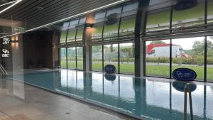 ein Swimmingpool in der Mitte eines Gebäudes mit Fenstern in der Unterkunft Omega Lake Apartments Nr 60 in Olsztyn + 5 Fotos