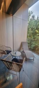 eine Terrasse mit 2 Stühlen, einem Tisch und Stühlen in der Unterkunft Omega Lake Apartments Nr 60 in Olsztyn