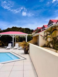 un cortile con piscina e una casa di Cottage de Pinel Terrasse & Piscine tropicale a Cul de Sac