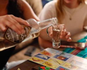 a woman pouring a drink from a glass at El Pinche Hostal in Guadalajara