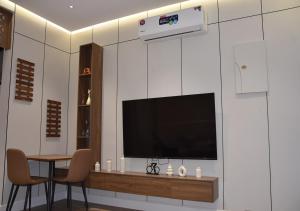 a living room with a television and a table with chairs at شقه فرح Farah Apartment in Hail