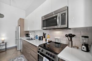 una cocina con estufa y microondas en Stunning Downtown Apartment with Pool, Laundry, Parking, en Dallas